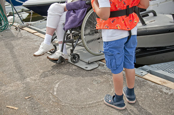 A person in a wheelchair drives over an extended bow ramp. Photo Katharina Ratzka