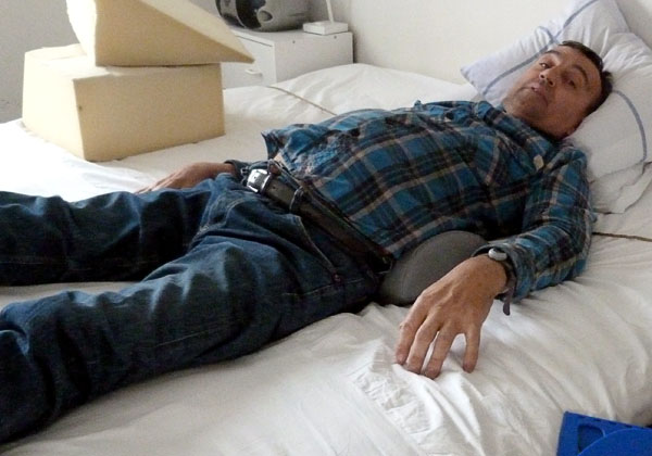 User lying on his back with lumbar cushion