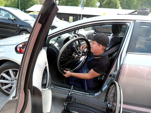 User takes wheelchair wheels into car