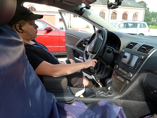 User in vehicle driver's seat, covers on the passenger seat