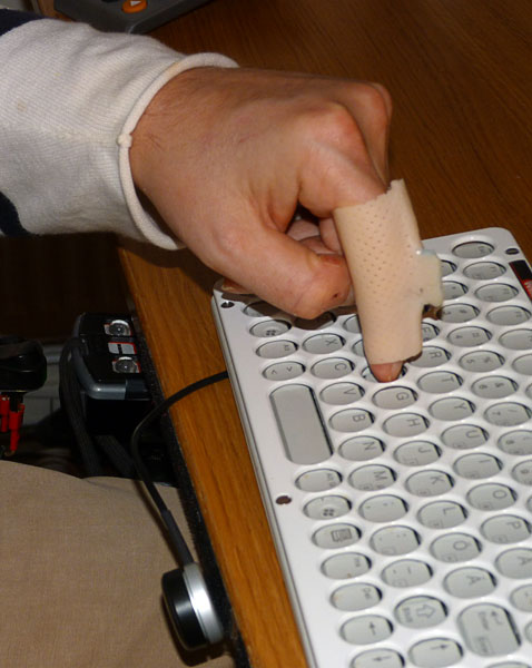 User at the keyboard with finger orthotic