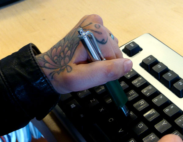 Användaren håller touchpennen med vänster hand (nypgrepp).