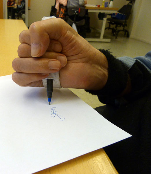 User writes with pen in universal strap