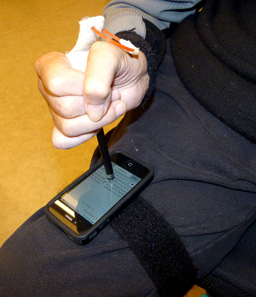 The user writes text messages on his iPhone with the stylus