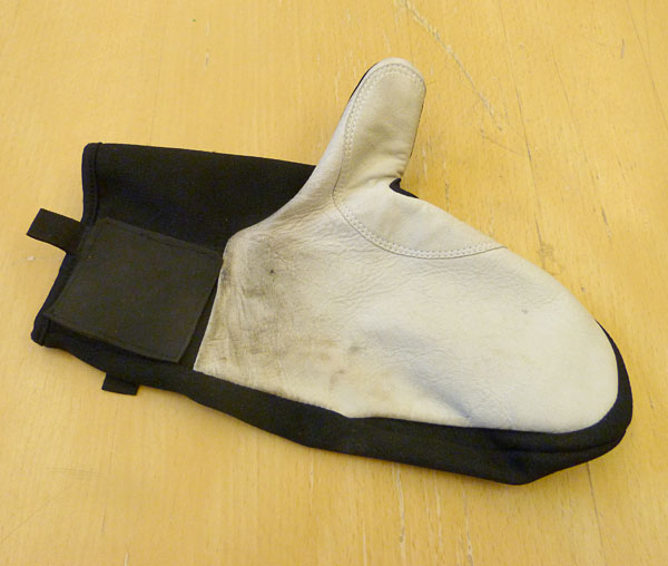 The mitten with a piece of hard rubber on palm at the level of the wrist.