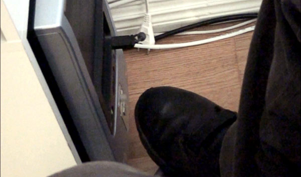 User with foot on the computer’s power button