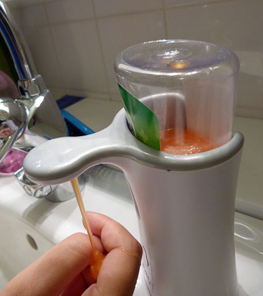 The user holds his hand under the soap pump and soap flows into his hand.