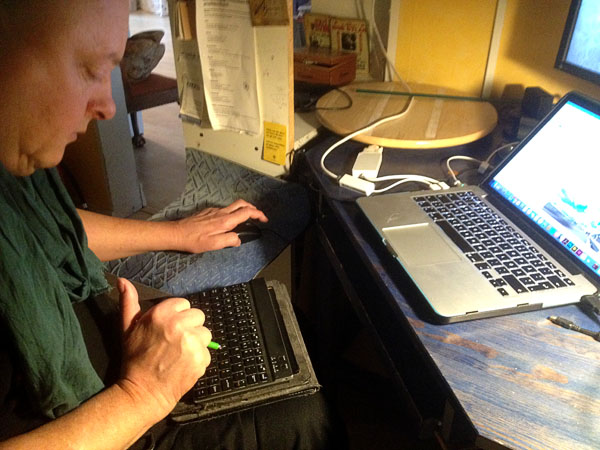 Användaren styr sin dator med ett minitangentbord på knäna