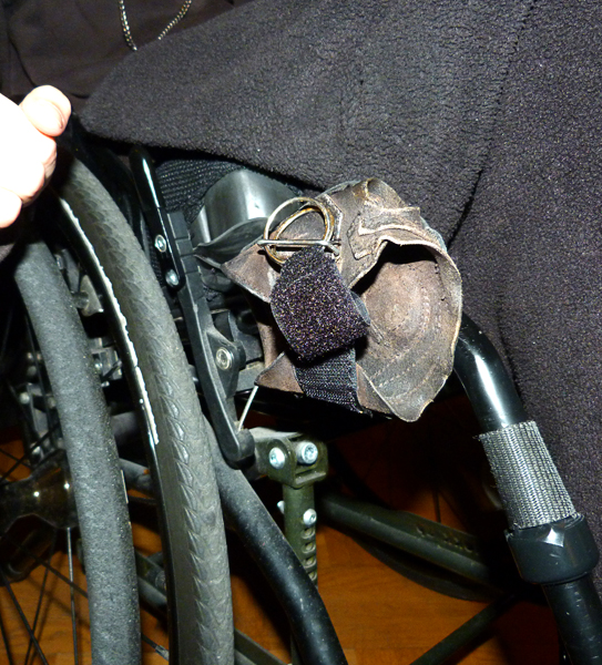 Wheelchair glove attached to wheelchair frame