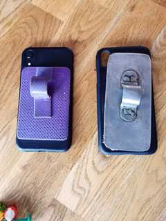 2 telefoner bakifrån med olika telefonhållare: den vänstra är gjort av ortosmaterial, den högra av tunnplåt